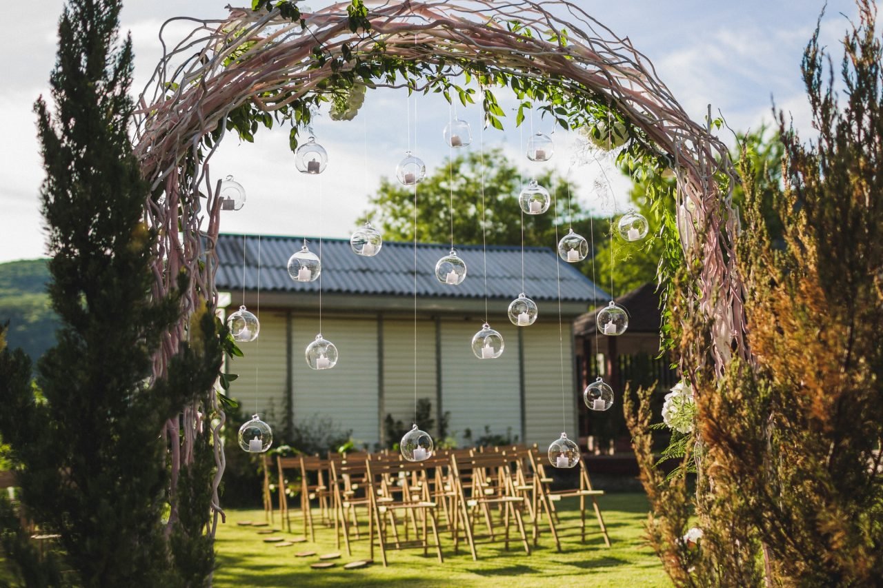 Bride and groom under garden arch at evening wedding ceremony