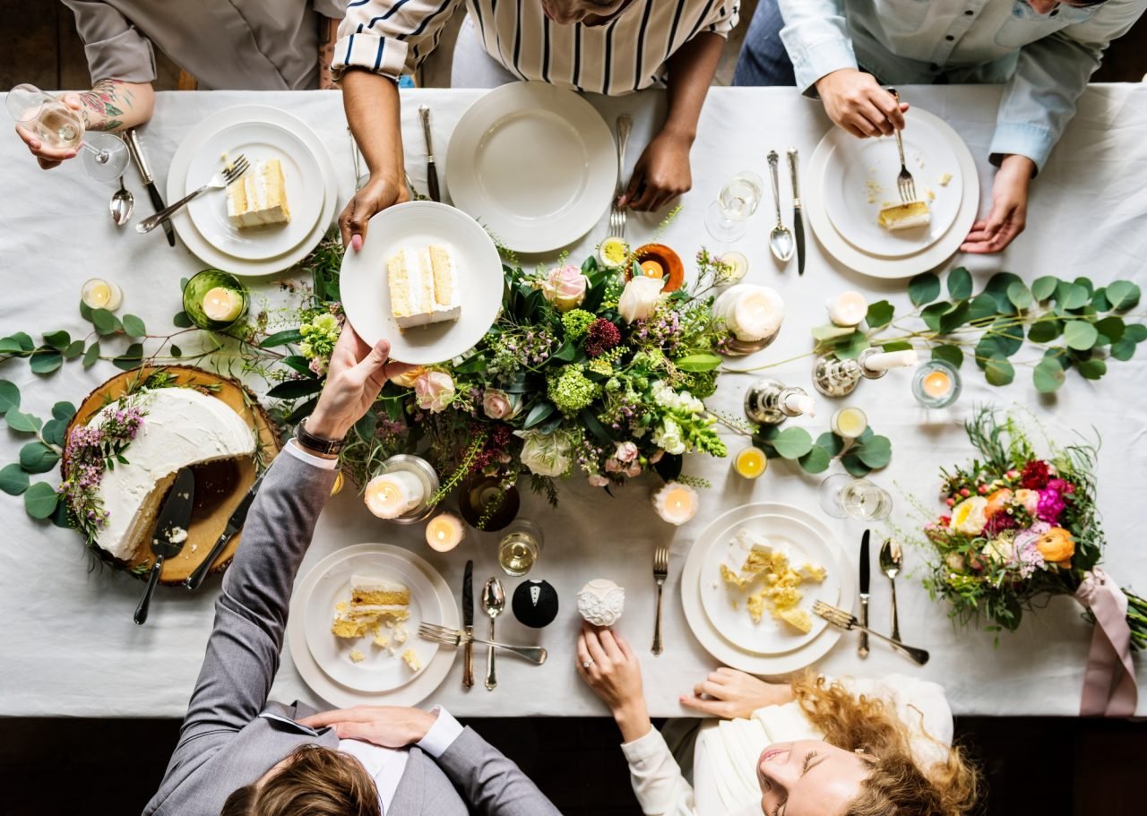 wedding party sharing a cake at a table