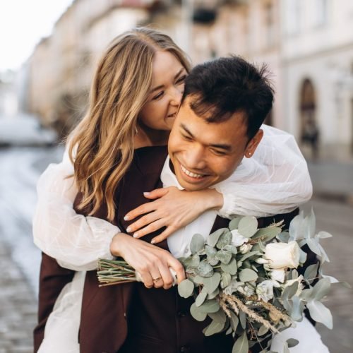 International wedding couple — European bride and Asian groom walking around the city together